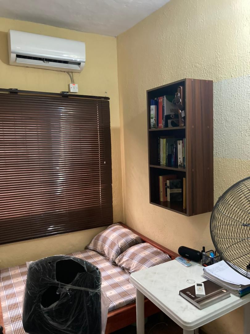 Bed space room with ceiling fan and two beds at Rilwan AJALA Homes Yaba