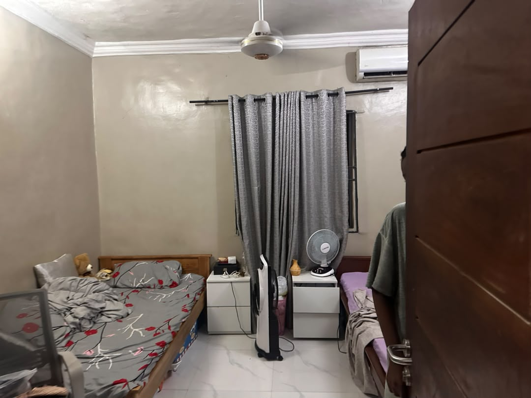 Bed space room at Rilwan AJALA Homes with AC, ceiling fan and grey curtains