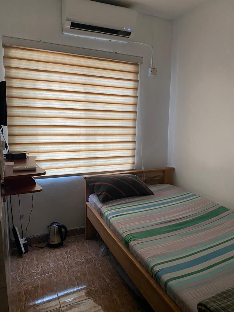 Standard single room at Ajala Homes with air conditioning, roller blind, single bed, and wooden desk