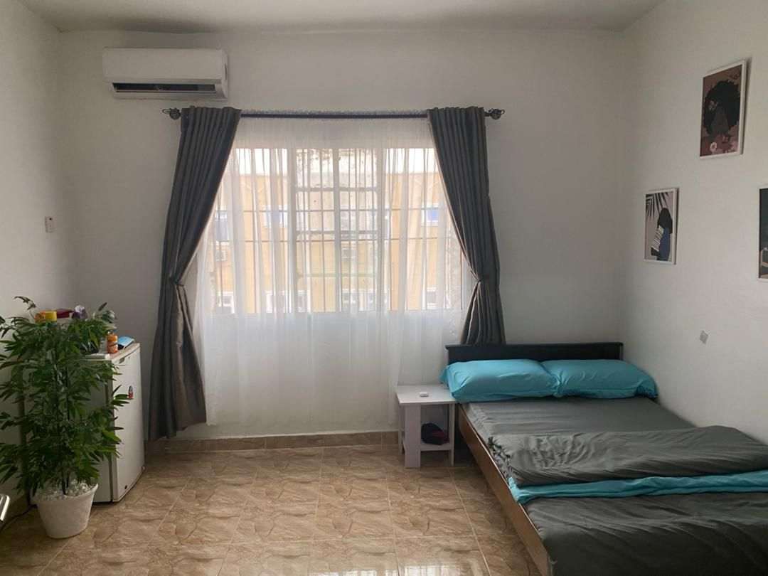 Mini flat room with teal bedding and fridge at Rilwan AJALA Homes Yaba